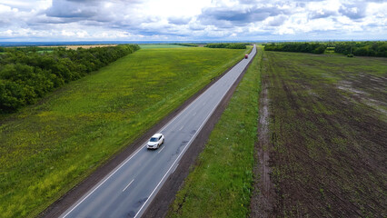 trucks are driving on the highway, surrounded by summer green fields