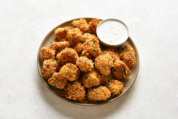 Crispy breaded oven baked cauliflower bites served with dipping sauce