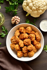 Breaded oven baked cauliflower bites in bowl on wooden table