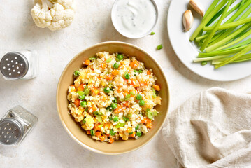 Cauliflower fried rice with carrot, green pea, corn, scrambled eggs in bowl