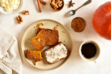 Sliced pumpkin bread with butter on light stone background