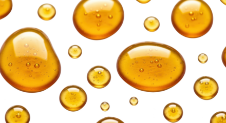 Creative composition of golden liquid serum or honey drops on a white background focused on drop,