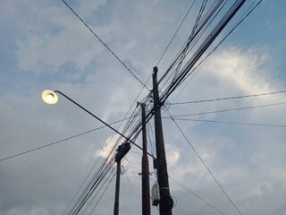 Fototapeta premium Utility poles with intersecting power lines and a street light 