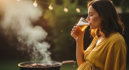 Pregnant woman enjoying a refreshing drink outdoors at a lively evening barbecue