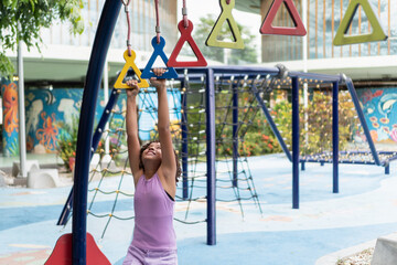 Young girl playing on monkey bars celebrating children's day
