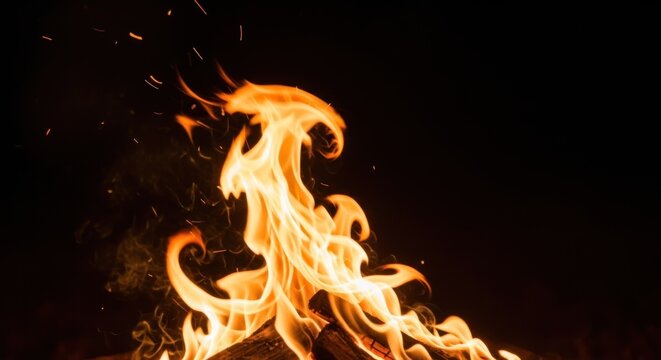 Vibrant orange and yellow flames dance against a dark background, with sparks flying - Powered by Adobe