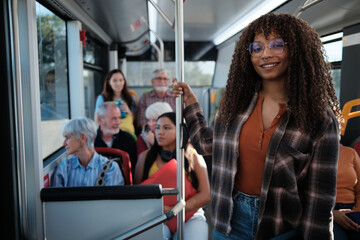 Smiling woman commuting on public transport with diverse passengers