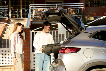 Couple packing car trunk for summer road trip