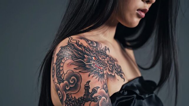 Woman with Intricate Dragon Tattoo - A woman is shown with an intricate dragon tattoo on her shoulder, surrounded by stylized clouds and shading.
