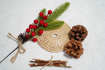 Festive Arrangement of Pine Cones, Red Berries, and Green Pine Sprigs on a Natural Fiber Mat for Seasonal Decor and Holiday Craft Projects