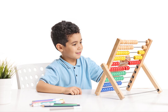 Cute boy studying maths with an abacus on a table