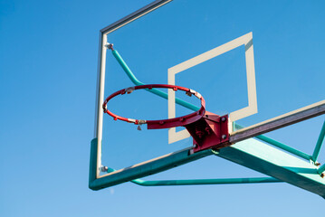 Red Basketball Hoop Without Net Against Blue Sky.