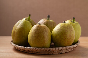Fresh pear in basket on wooden background