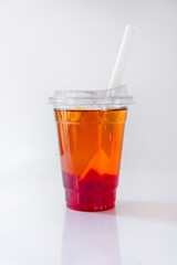 Orange lemonade in a plastic cup with a straw