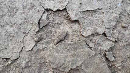 Weathered cracked concrete texture revealing layered erosion patterns across rugged fractured surface ideal for raw architectural detail studies on white background