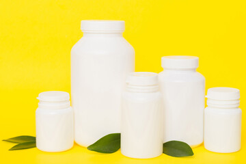 supplement pills with medicine bottle health care and medical top view. Vitamin tablets. Top view mockup bottle for pills and vitamins with green leaves, natural organic bio supplement, copy space