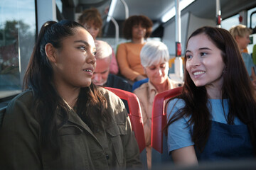 Women friends talking on public transport bus
