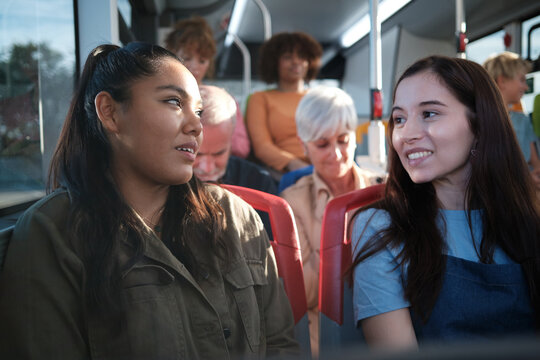 Women friends talking on public transport bus - Powered by Adobe