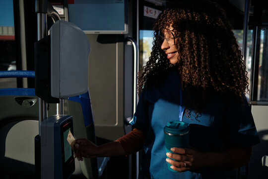 Young woman paying bus fare using contactless card