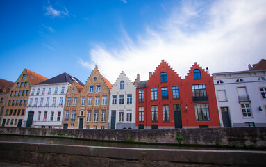 Bruges, Belgium - September 12 2025. Editorial image of colorful traditional Flemish gabled houses along a canal in Bruges, Belgium, on a bright sunny day.