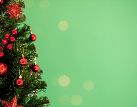 Christmas background with xmas tree, Christmas red decoration and sparkle bokeh lights on green background. Merry Christmas greeting card. Winter holiday theme. Happy New Year. Space for text