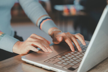 Female hands using laptop touchpad and keyboard.Business woman working on computer modern remote work at home,freelance lifestyle,digital communication concept in soft natural lighting environment