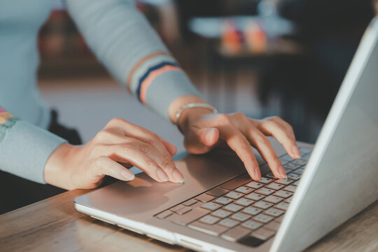 Female hands using laptop touchpad and keyboard.Business woman working on computer modern remote work at home,freelance lifestyle,digital communication concept in soft natural lighting environment - Powered by Adobe