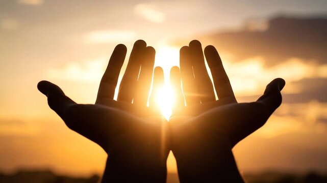 Hands reaching towards the sun in a golden hour scene concept of hope or spirituality