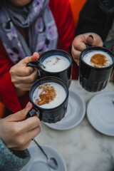Women's hands is holding cups of hot salep