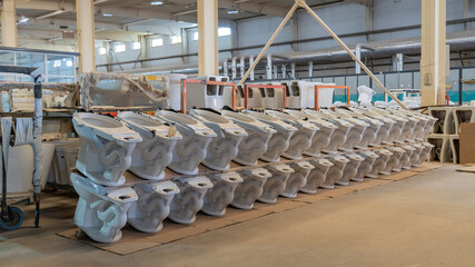Neatly arranged sanitary ceramic components in a ceramic toilet production workshop