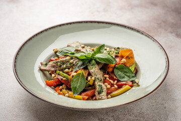 Beef with vegetables and basil served in restaurant bowl