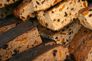 Close-up of freshly cut fruit bread slices with visible dried fruits and nuts, highlighting their texture and golden-brown crust.