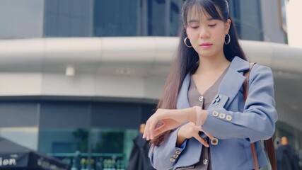 Young happy business businesswoman, modern office setting, outdoor city street, walking travel, checking watch, confident urban professional, ready for successful productive day ahead.