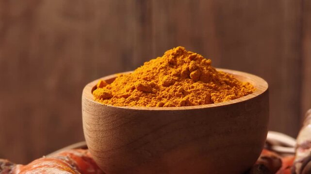 Turmeric powder in a wooden cup