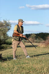 The hunter reloads his gun and prepares to shoot at game