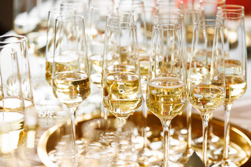 Champagne glasses arranged on golden tray