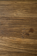 Naklejka premium A close-up of a wooden surface with rich brown tones and natural grain patterns. Darker stains add character and suggest aging or usage.