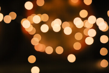 Defocused warm circular bokeh lights forming an abstract pattern on dark background, captured using shallow depth of field