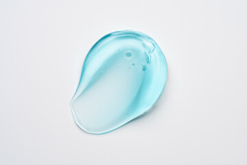 Glycerin gel texture. Transparent blue serum drop on white background. Liquid gel moisturizer with bubbles macro.