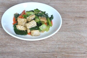 fried Kailaan Chinese kale and carrot with tofu dressing soy sauce vegetarian food on plate
