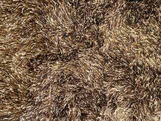 Close up of carpet rug flooring in dark brown tuft color. Fabric with feather and fur in brown color. Seamless modern minimalist rug texture with tufted fur. Suitable for living room floor.