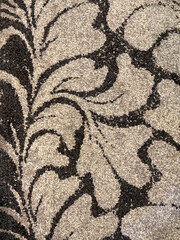 Close up of carpet texture in random black and beige leaves foliage pattern. For rug, carpet, fabric, and upholstery finishes. Seamless background texture.