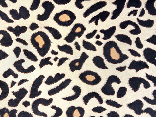 Close up of a graphic background with leopard skin pattern in yellow, gold, brown, and black color. Animal skin leopard texture seamless background.