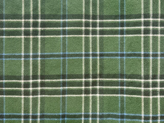 Close up of fabric with tartan pattern. In green and white color. Flannel or tartan style is very common in scarf, shirts, and fashion industry. Seamless background texture.