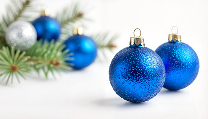 Blue Christmas baubles on pine branch with white background  