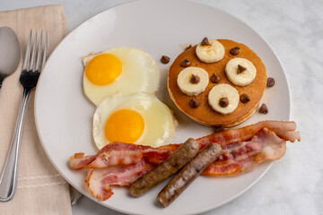 fried eggs with pancakes  ,bacon and sausage