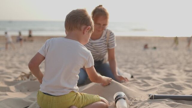 Mother and son building a sandcastle together on the beach