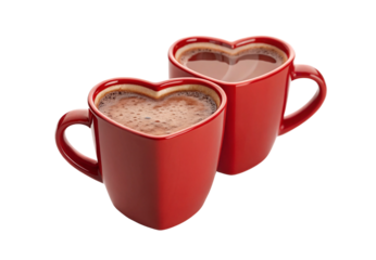 Two red heart-shaped ceramic mugs containing creamy hot chocolate beverage, isolated on a transparent background