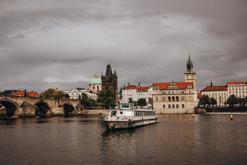 Fototapeta premium Historic Prague cityscape along the Vltava River with iconic Charles Bridge and architecture.