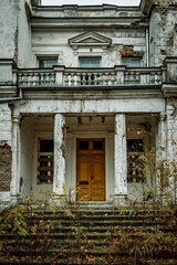 Fototapeta premium Old Abandoned Building with Cracked Facade and Yellow Doors